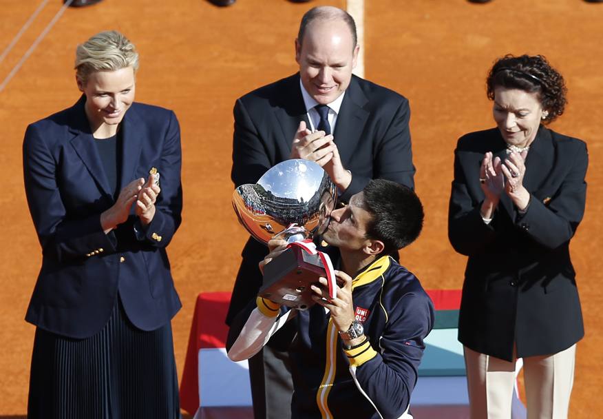 Novak Djokovic bacia il trofeo sotto lo sguardo attendo del Principe Alberto di Monaco. Afp